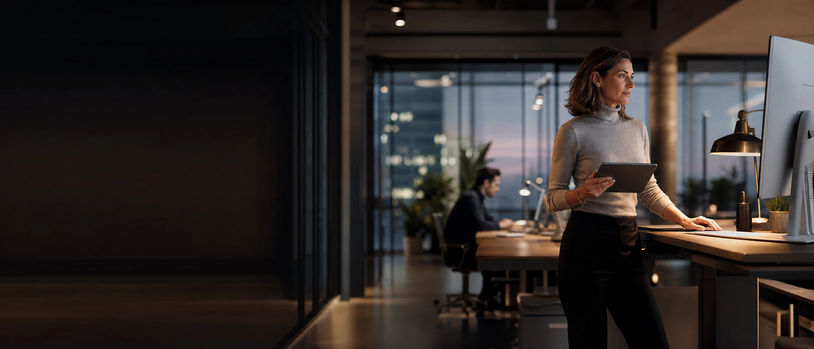 The agency founder at her standing desk after a call, open proposals on the screen beside her